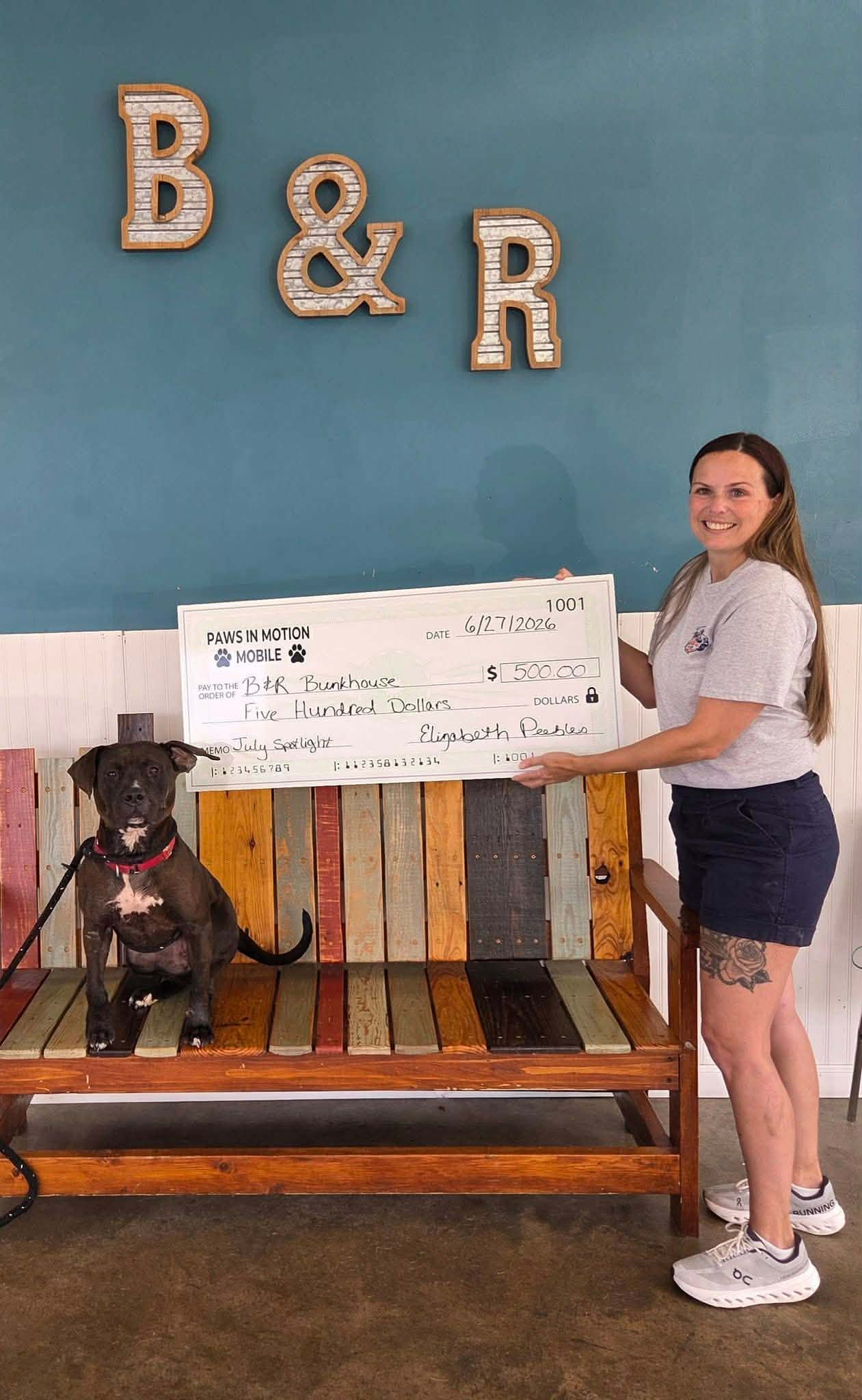 Liz presenting a $500 check to B&R Bunkhouse
